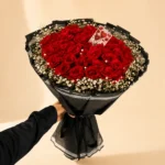 Heart-shaped red rose bouquet with white filler flowers