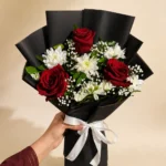 Red rose and white daisy bouquet with green foliage