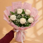 White rose bouquet with baby's breath and pink wrapping
